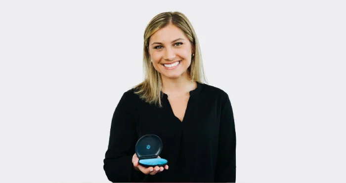girl holding up invisalign and giving thumbs up